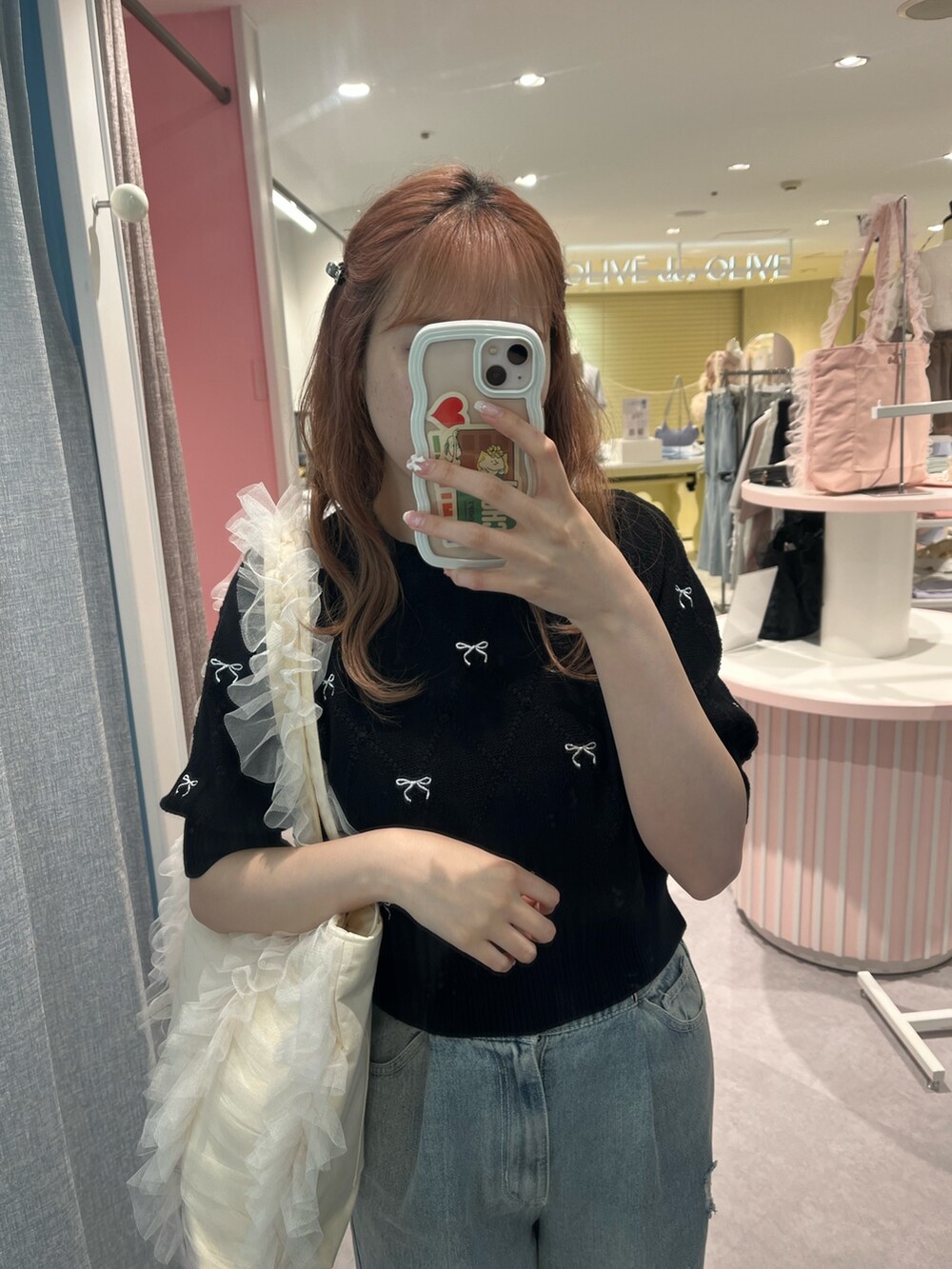 ブラック系のニット/セーター、ブルー系のデニムパンツ、ホワイト系のトートバッグを着用したレディースの夏コーディネートの2枚目の写真