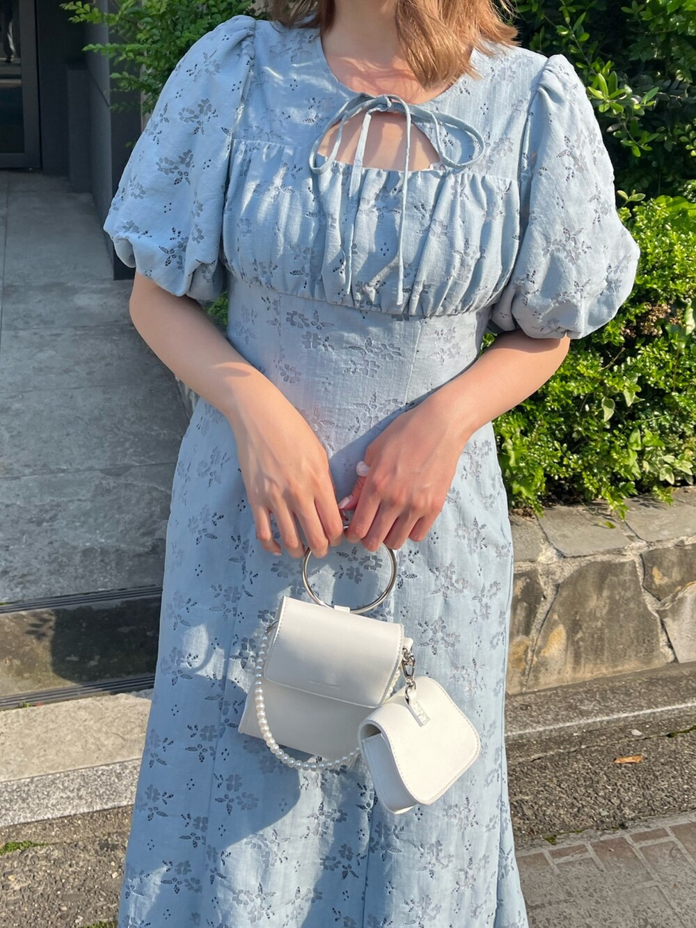 ブルー系のワンピース、ホワイト系のサンダル、ホワイト系のショルダーバッグを着用したレディースの春コーディネートの3枚目の写真