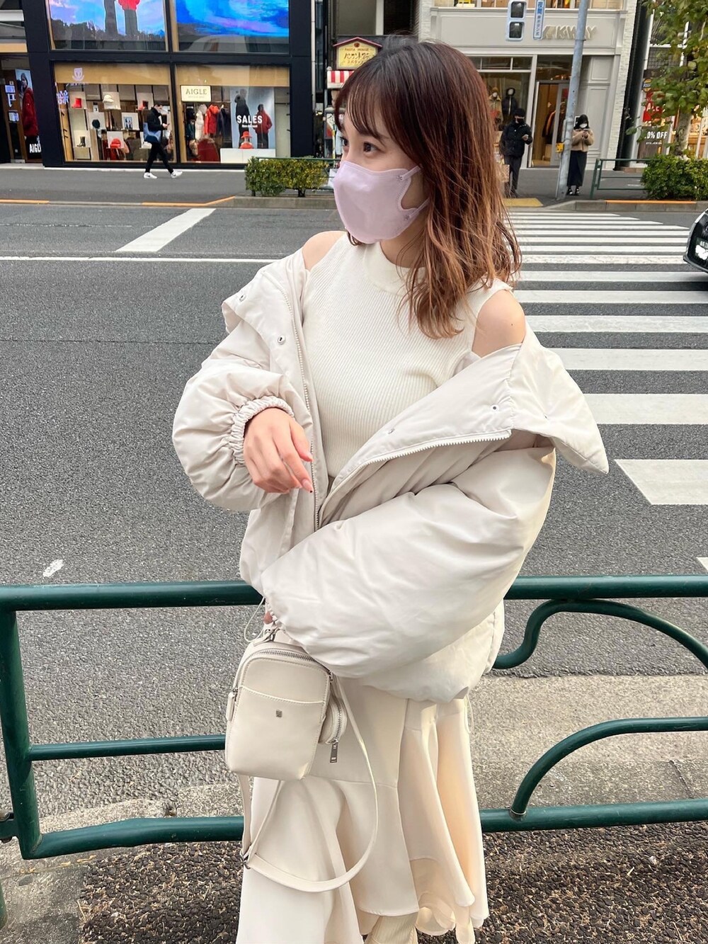 ブラック系のダウンジャケット/コート、ホワイト系のスカート、ホワイト系のショルダーバッグを着用したレディースの冬コーディネートの2枚目の写真