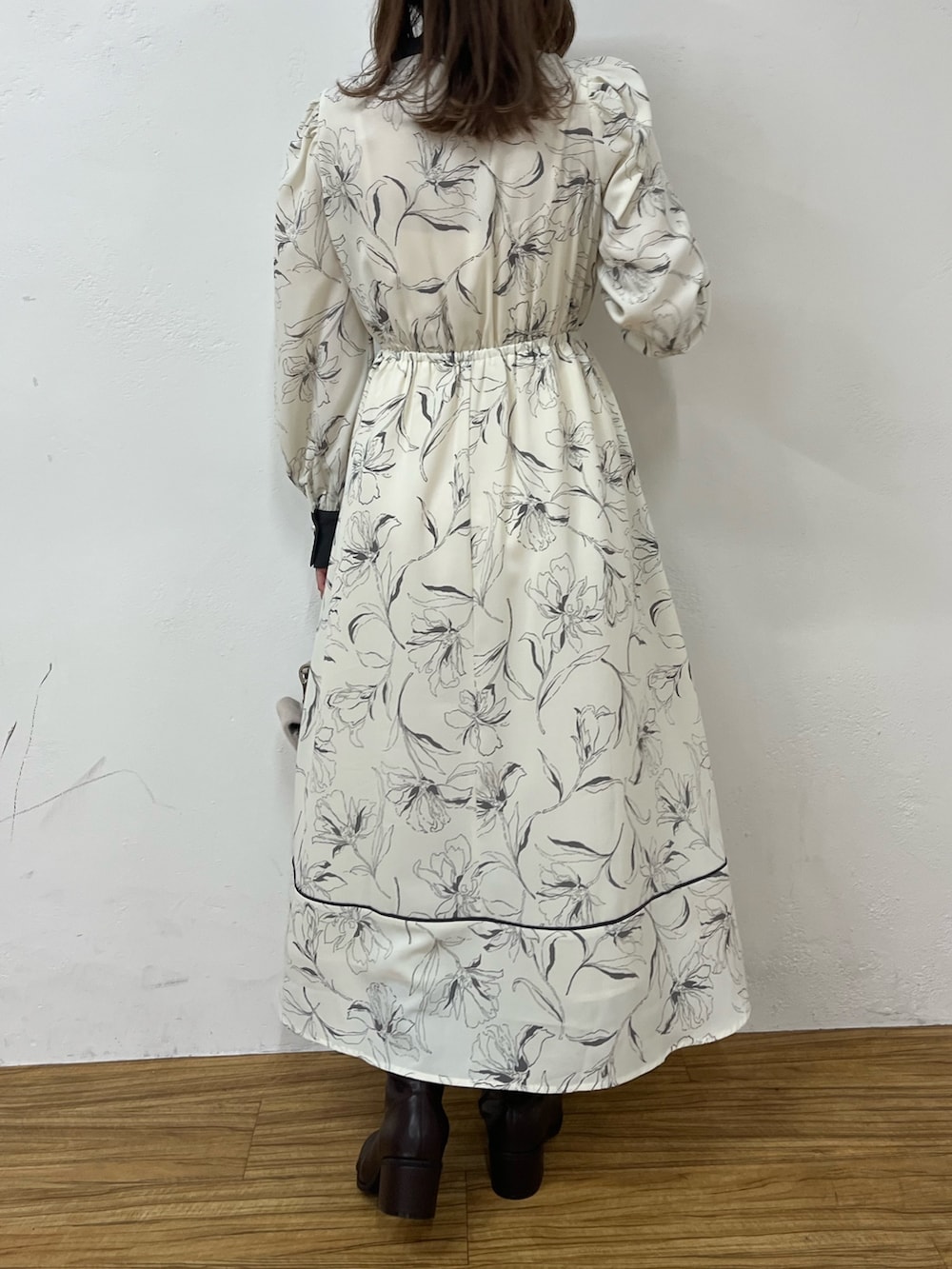 ホワイト系のワンピース、ベージュ系のショルダーバッグ、ブラック系のブーツを着用したレディースの秋コーディネートの2枚目の写真