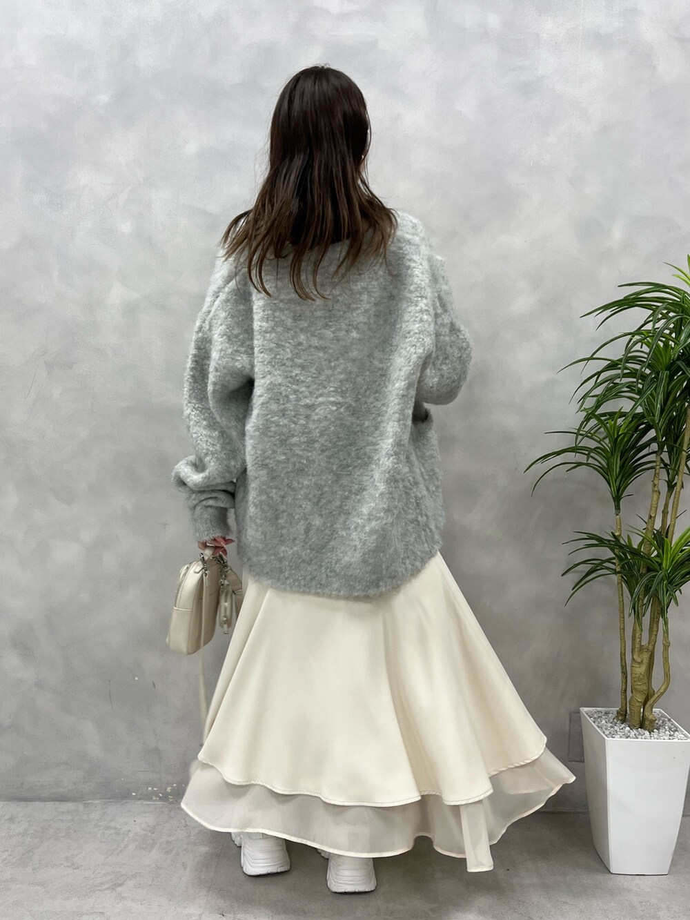 ブルー系のワンピース、ベージュ系のカーディガン/ボレロ、ホワイト系のスニーカーを着用したレディースの夏コーディネートの2枚目の写真