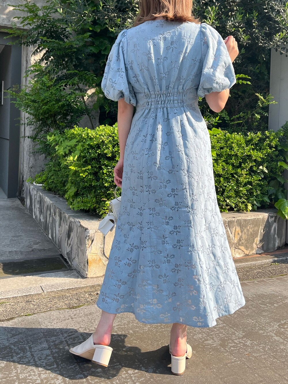 ブルー系のワンピース、ホワイト系のサンダル、ホワイト系のショルダーバッグを着用したレディースの春コーディネートの2枚目の写真