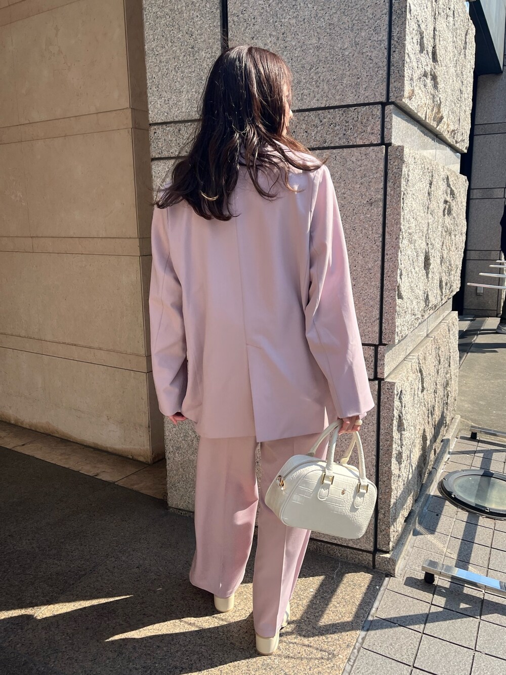 ピンク系のテーラードジャケット、ホワイト系のブーツを着用したレディースの夏コーディネートの2枚目の写真
