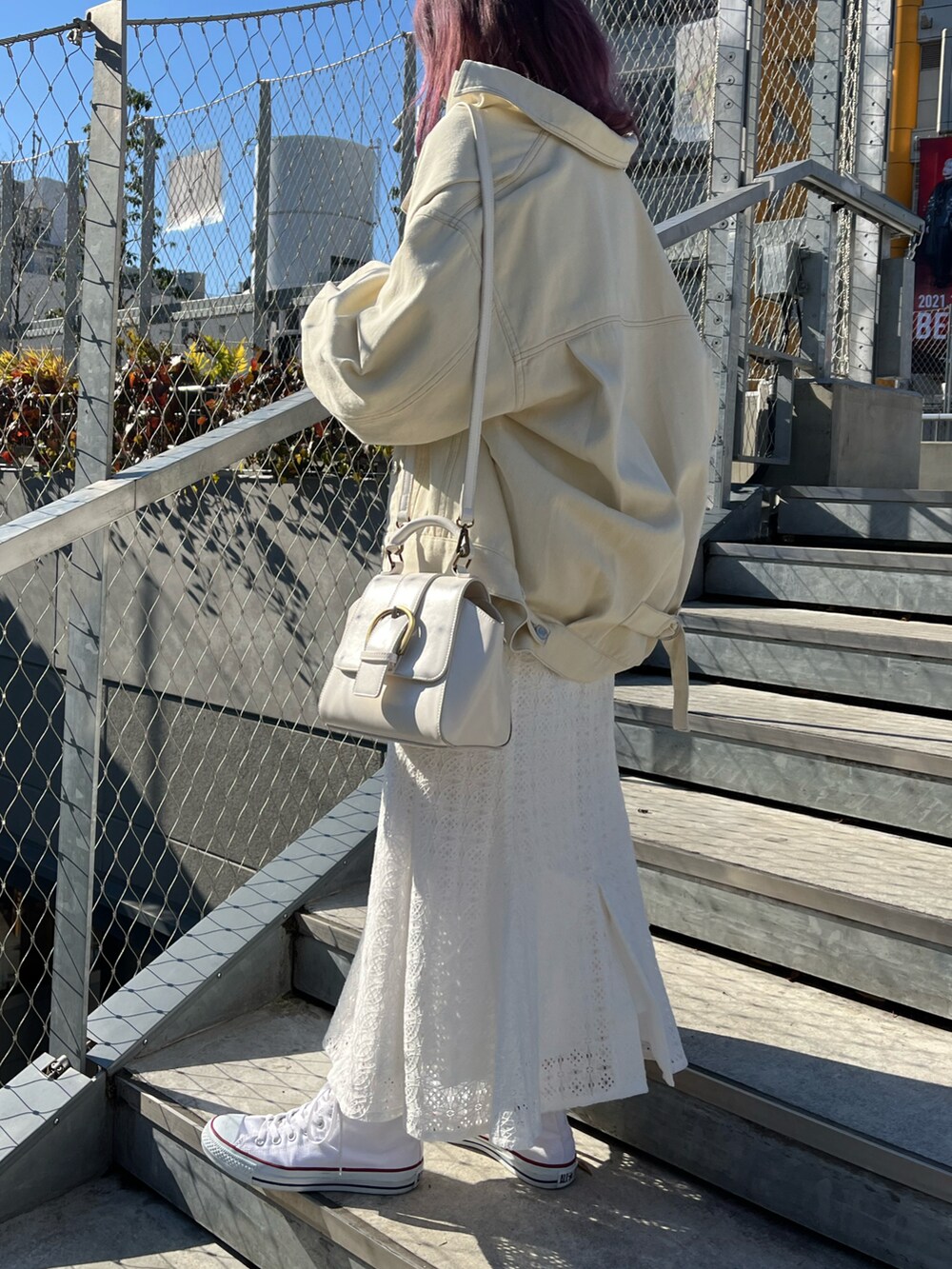 グレー系のスウェット、ホワイト系のデニムジャケット、ホワイト系のスカートを着用したレディースの冬コーディネートの2枚目の写真