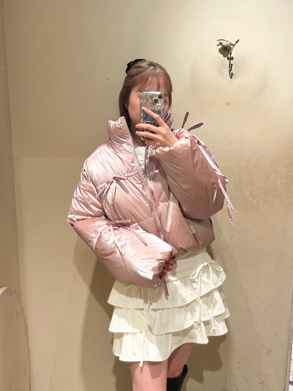 ピンク系のダウンジャケット/コート、ホワイト系のスカート、ブラック系のブーツを着用したレディースの冬コーディネートの2枚目の写真