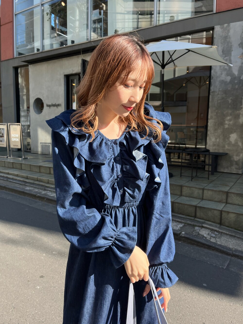 ブルー系のワンピース、ブルー系のトートバッグ、ベージュ系のブーツを着用したレディースの冬コーディネートの2枚目の写真