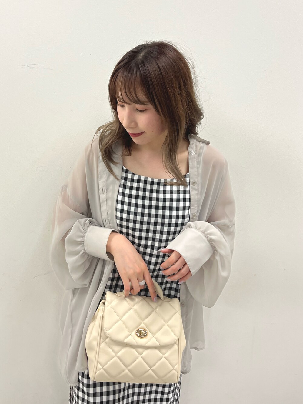 ホワイト系のショルダーバッグ、グレー系のシャツ/ブラウス、ホワイト系のワンピースを着用したレディースの春コーディネートの3枚目の写真