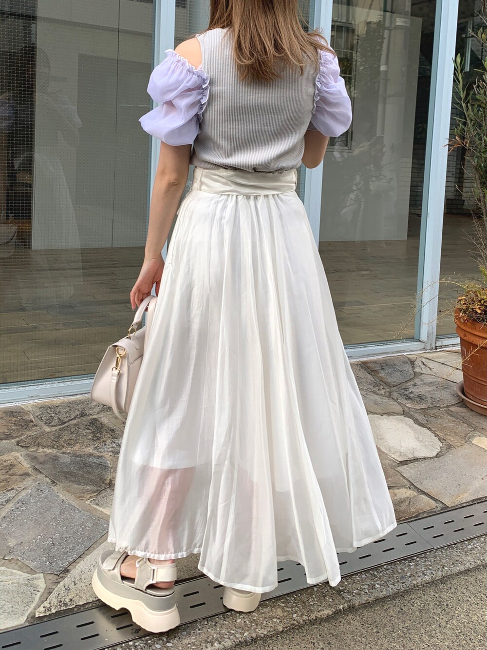 グレー系のTシャツ/カットソー、ホワイト系のスカート、ホワイト系のサンダルを着用したレディースの春コーディネートの3枚目の写真