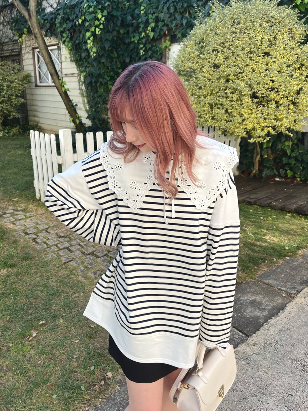 ホワイト系のTシャツ/カットソー、ブラック系のスカート、ホワイト系のブーツを着用したレディースの冬コーディネートの2枚目の写真