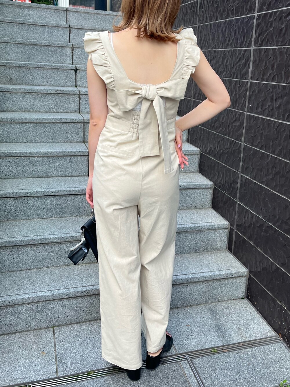 ベージュ系のサロペット/オーバーオール、ブラック系のショルダーバッグ、ブラック系のサンダルを着用したレディースの夏コーディネートの2枚目の写真