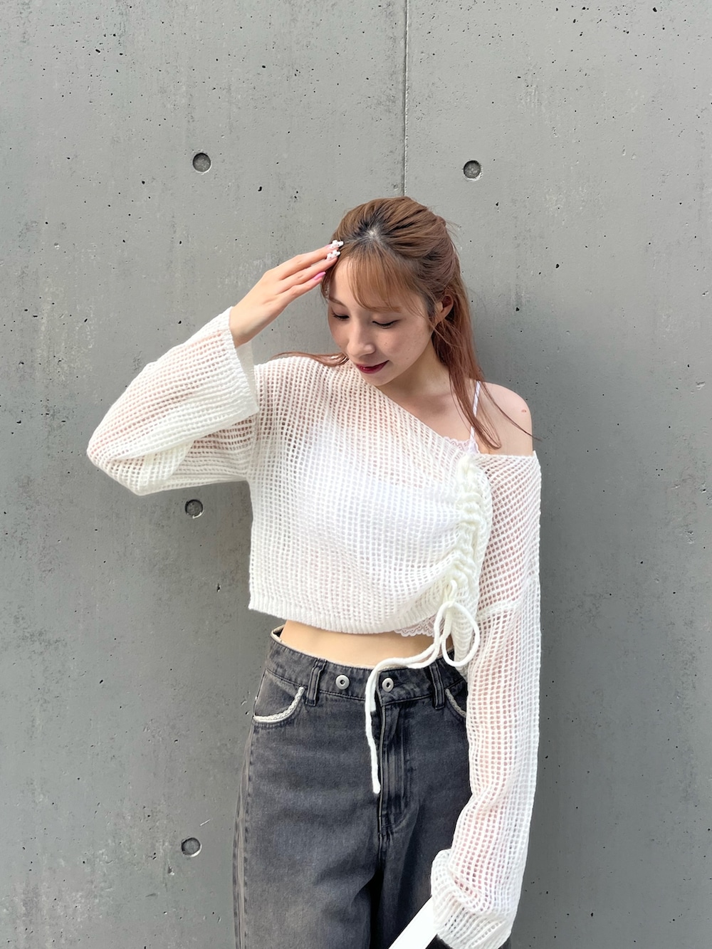 ホワイト系のニット/セーター、ブラック系のデニムパンツ、ホワイト系のスニーカーを着用したレディースの秋コーディネートの2枚目の写真