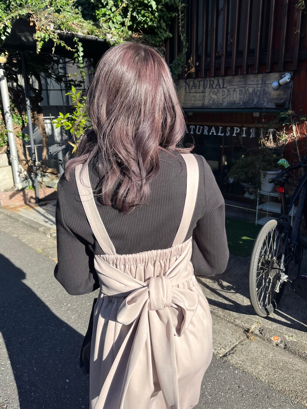 ベージュ系のワンピース、ブラック系のTシャツ/カットソー、ブラック系のショルダーバッグを着用したレディースの春コーディネートの2枚目の写真