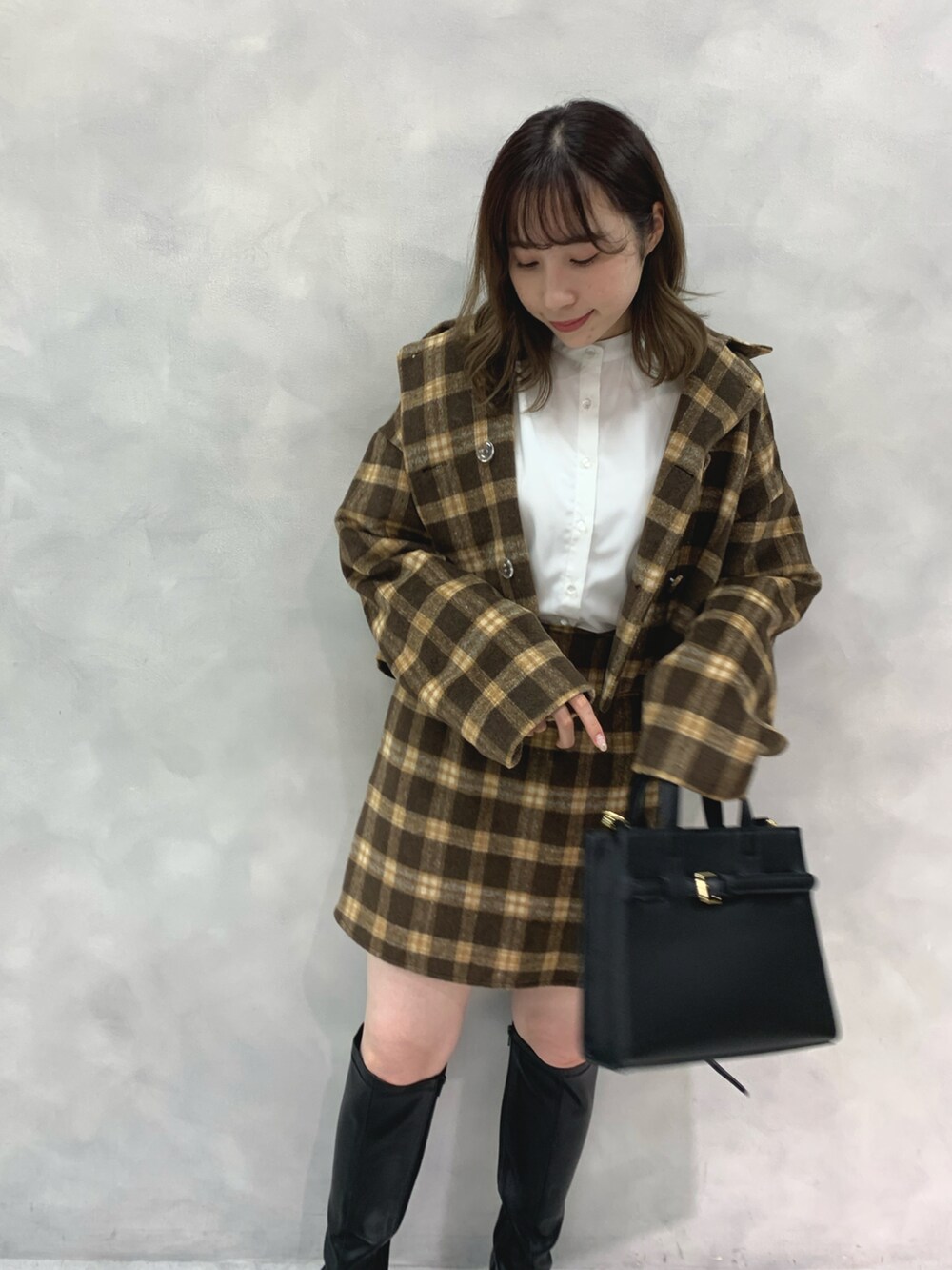 ブラウン系のワンピース、ブラック系のブーツ、ブラック系のショルダーバッグを着用したレディースの秋コーディネートの3枚目の写真