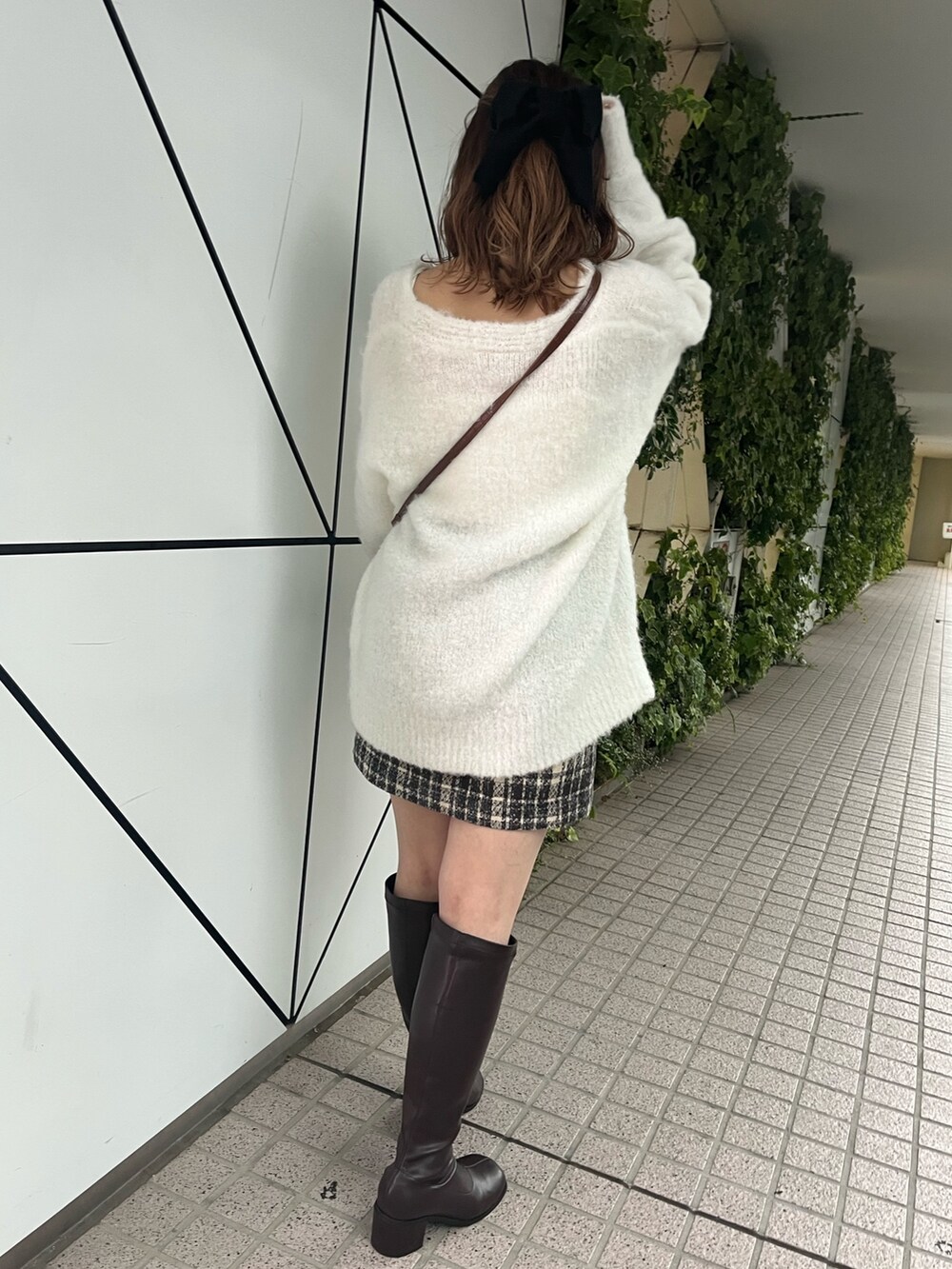 ホワイト系のカーディガン/ボレロ、ブラウン系のショルダーバッグ、ブラウン系のスカートを着用したレディースの秋コーディネートの2枚目の写真