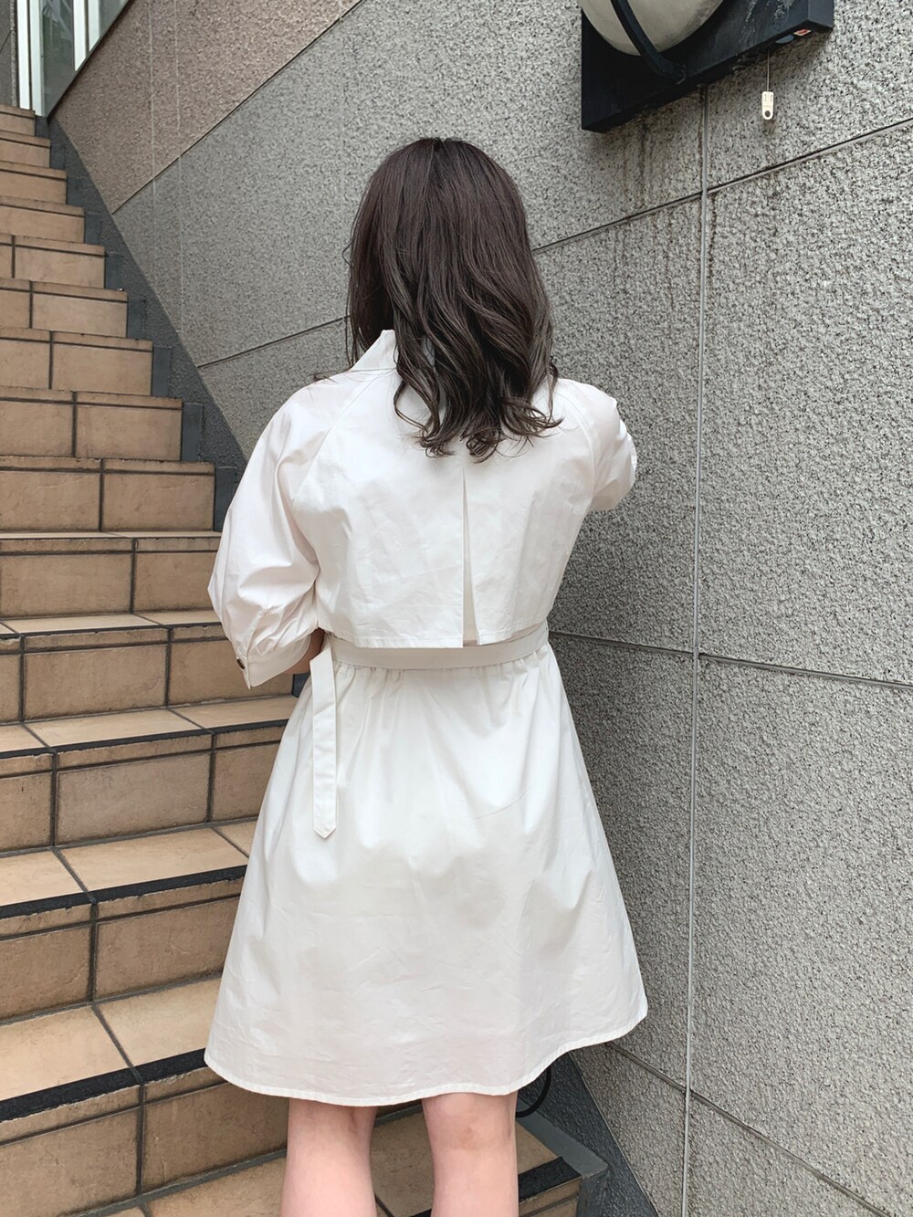 ホワイト系のワンピース、ブラック系のショルダーバッグ、ブラック系のブーツを着用したレディースの春コーディネートの2枚目の写真