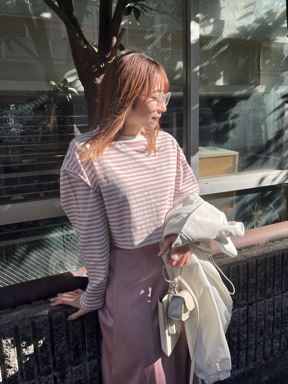 ピンク系のTシャツ/カットソー、ピンク系のスカート、ホワイト系のブーツを着用したレディースの冬コーディネートの2枚目の写真