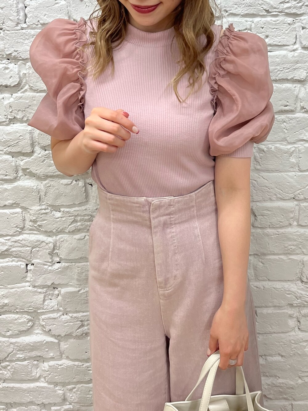 パープル系のTシャツ/カットソー、パープル系のデニムパンツ、ホワイト系のショルダーバッグを着用したレディースの春コーディネートの3枚目の写真