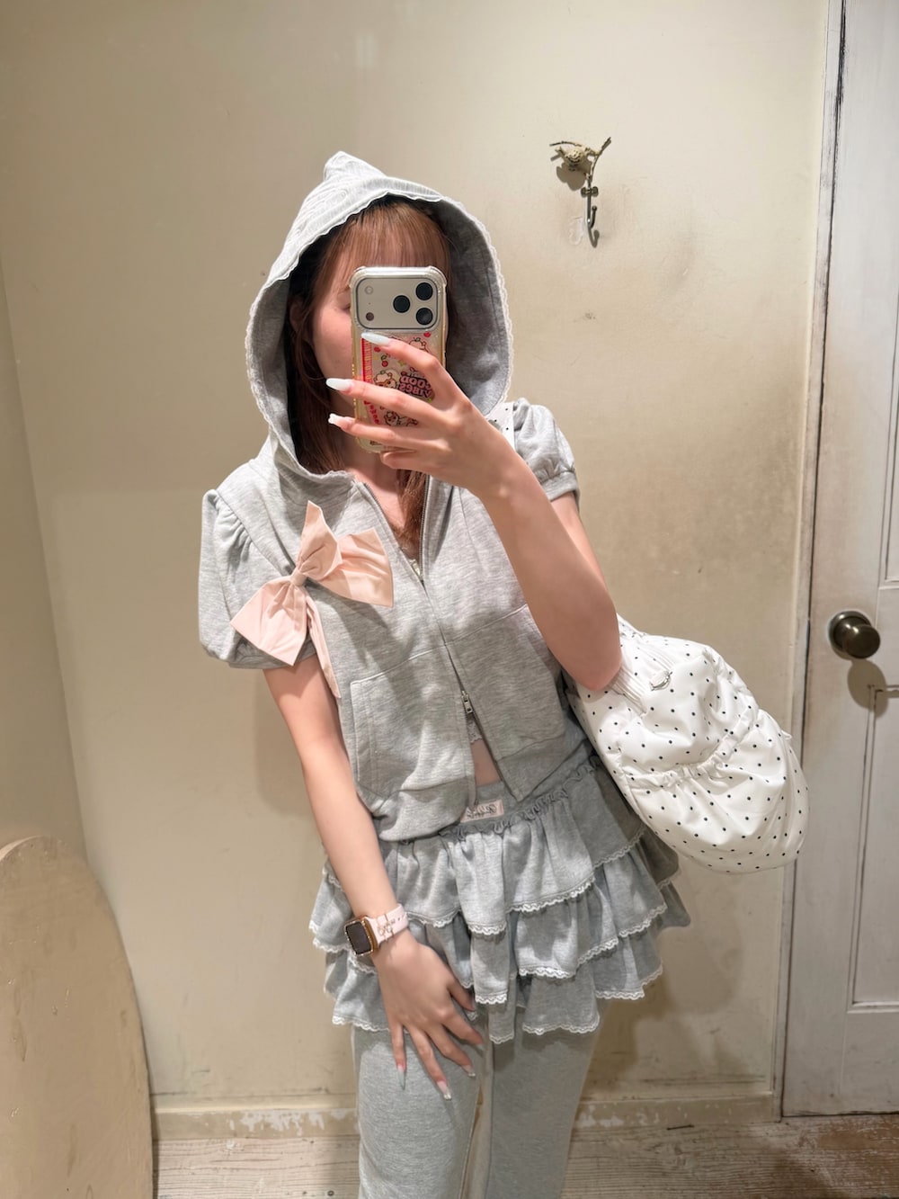 ホワイト系のボストンバッグ、グレー系のパーカー、グレー系のパンツを着用したレディースの夏コーディネートの2枚目の写真