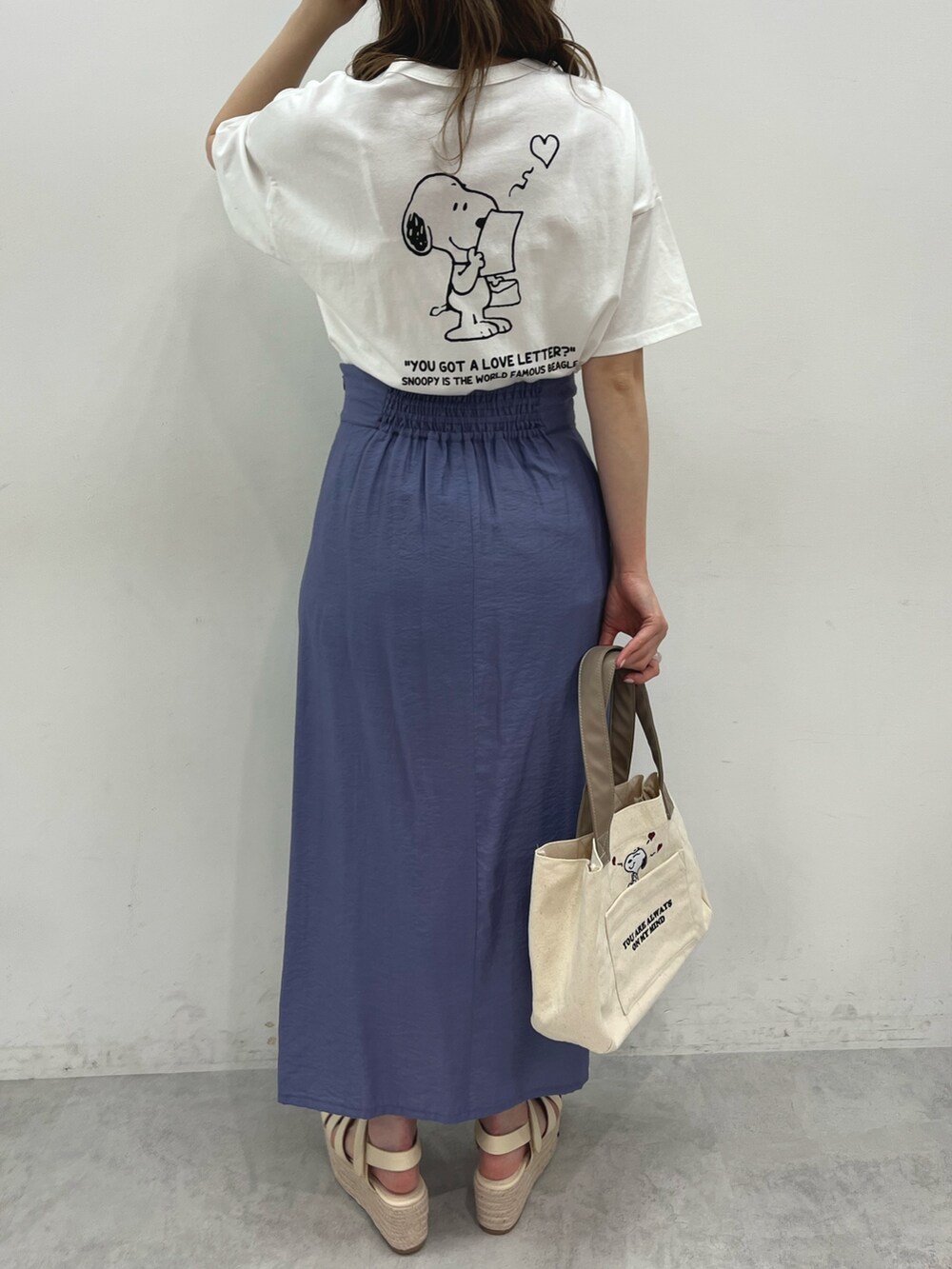 ホワイト系のTシャツ/カットソー、ブルー系のスカート、ホワイト系のバッグを着用したレディースの春コーディネートの2枚目の写真