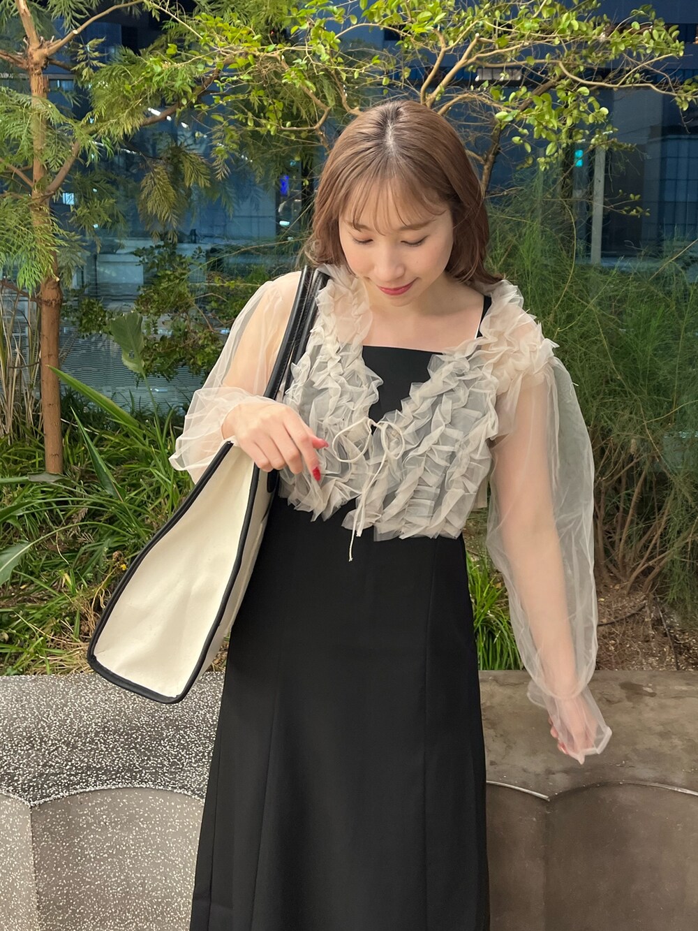 ブラック系のドレス、ホワイト系のトートバッグを着用したレディースの冬コーディネートの2枚目の写真