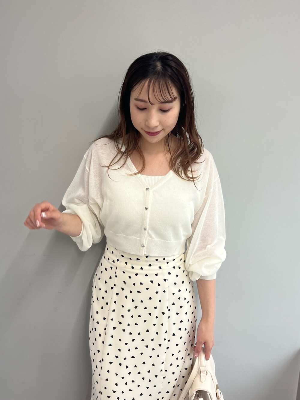 ホワイト系のカーディガン/ボレロ、ホワイト系のスカート、ホワイト系のショルダーバッグを着用したレディースの春コーディネートの2枚目の写真