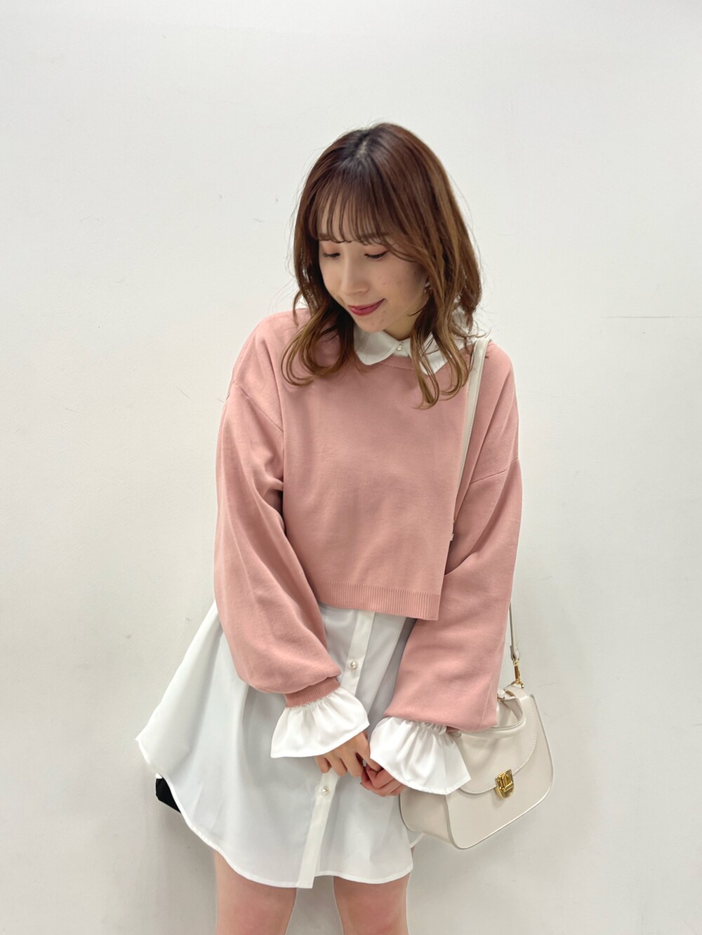 ピンク系のTシャツ/カットソー、ホワイト系のブーツ、ホワイト系のショルダーバッグを着用したレディースの冬コーディネートの2枚目の写真