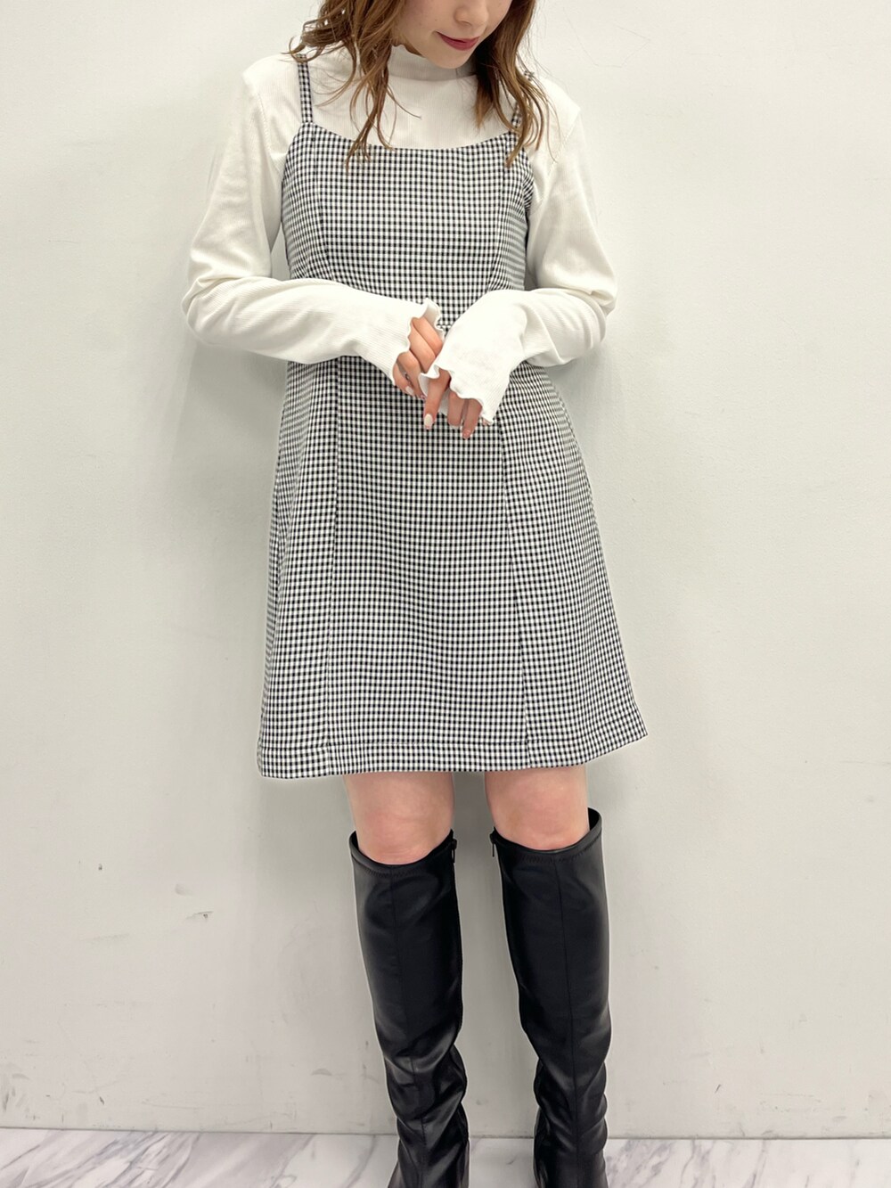 ブラック系のテーラードジャケット、ブラック系のワンピース、ブラック系のトートバッグを着用したレディースの冬コーディネートの2枚目の写真