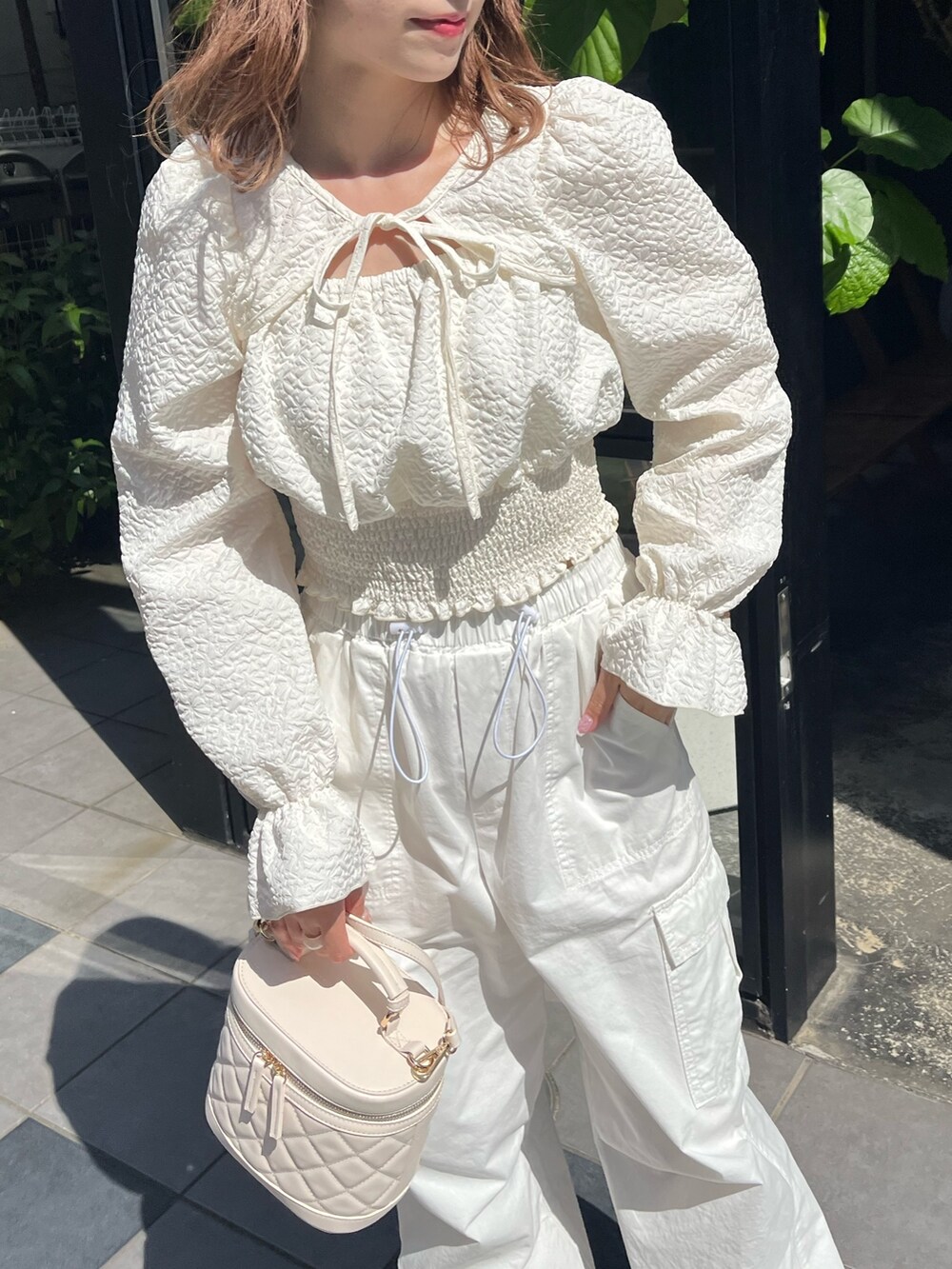 ホワイト系のシャツ/ブラウス、ホワイト系のカーゴパンツ、ベージュ系のスニーカーを着用したレディースの夏コーディネートの3枚目の写真