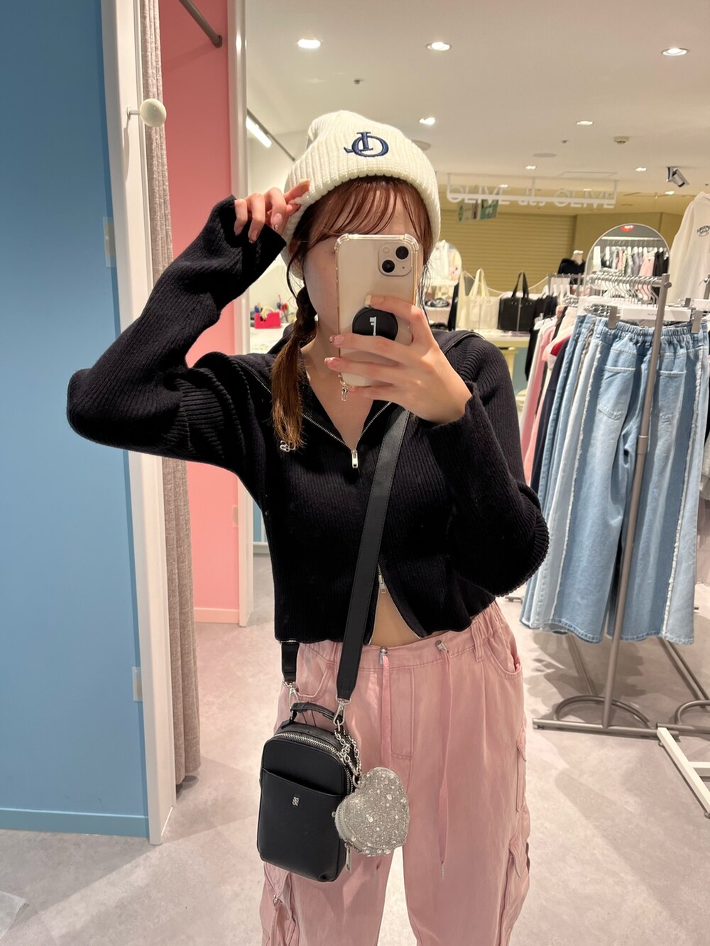 ブラック系のニット/セーター、ブルー系のカーゴパンツ、ピンク系のショルダーバッグを着用したレディースの秋コーディネートの2枚目の写真