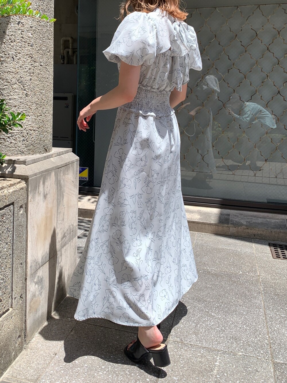 ブルー系のワンピース、ブラック系のショルダーバッグ、ブラック系のサンダルを着用したレディースの夏コーディネートの2枚目の写真