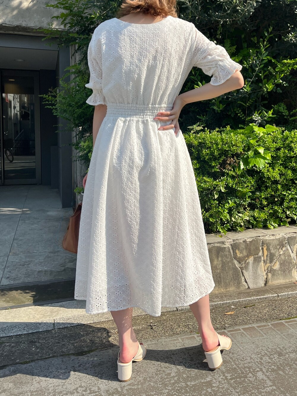 ホワイト系のワンピース、ブラウン系のショルダーバッグ、ホワイト系のサンダルを着用したレディースの春コーディネートの2枚目の写真