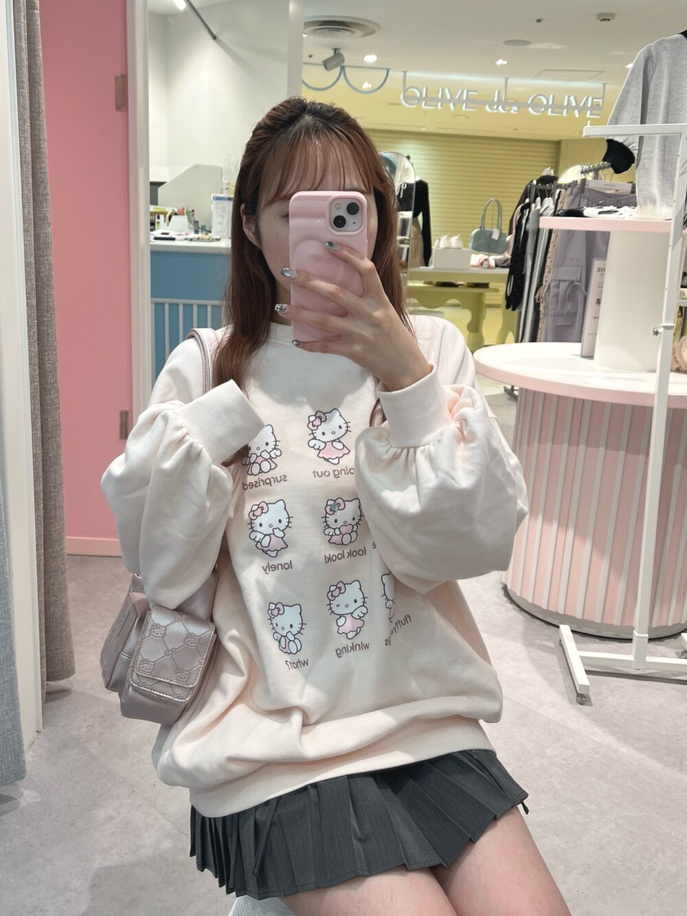 ピンク系のトップス、ピンク系のショルダーバッグ、ブラック系のブーツを着用したレディースの秋コーディネートの2枚目の写真