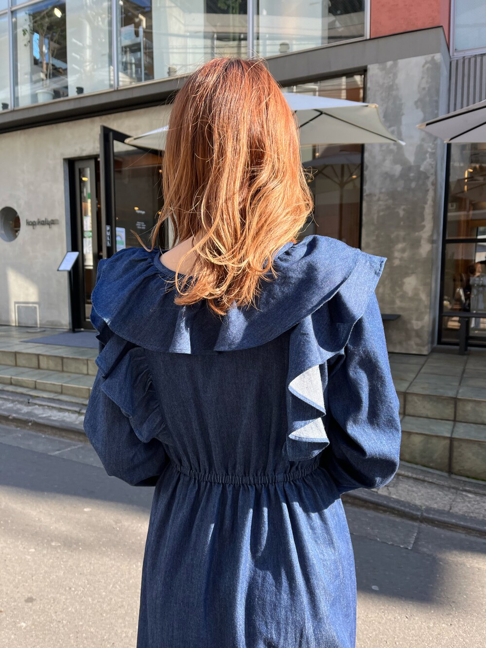 ブルー系のワンピース、ブルー系のトートバッグ、ベージュ系のブーツを着用したレディースの冬コーディネートの3枚目の写真
