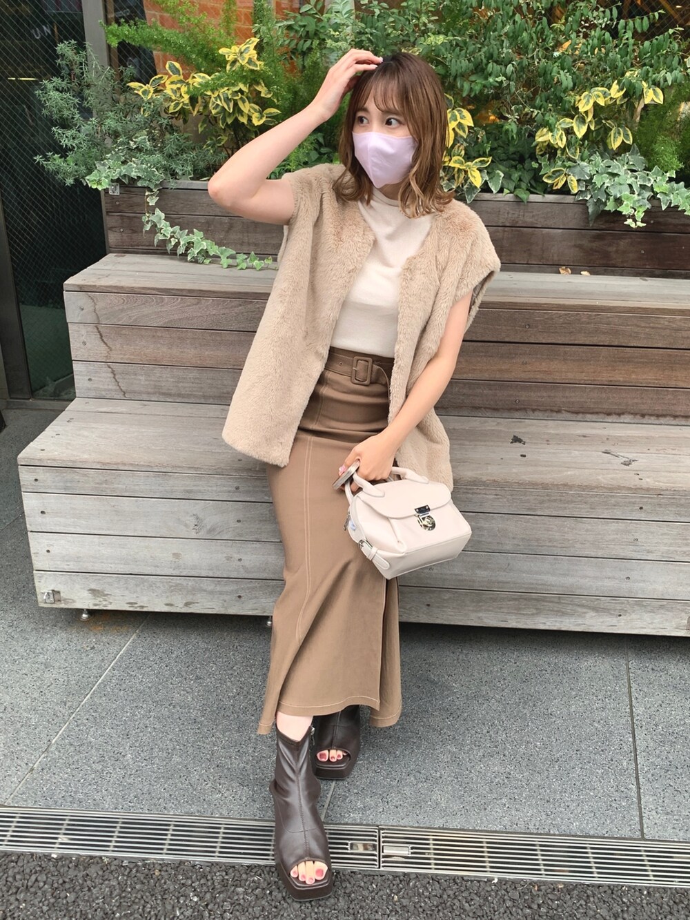 ブラウン系のスカート、ブラウン系のブーツ、ベージュ系のベストを着用したレディースの夏コーディネートの3枚目の写真