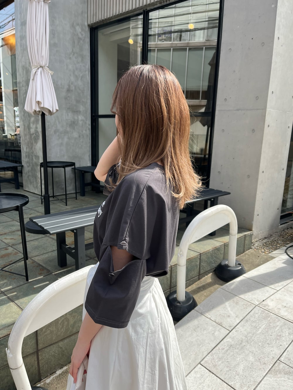 ブラック系のTシャツ/カットソー、ホワイト系のスカート、ゴールド系のサンダルを着用したレディースの春コーディネートの3枚目の写真