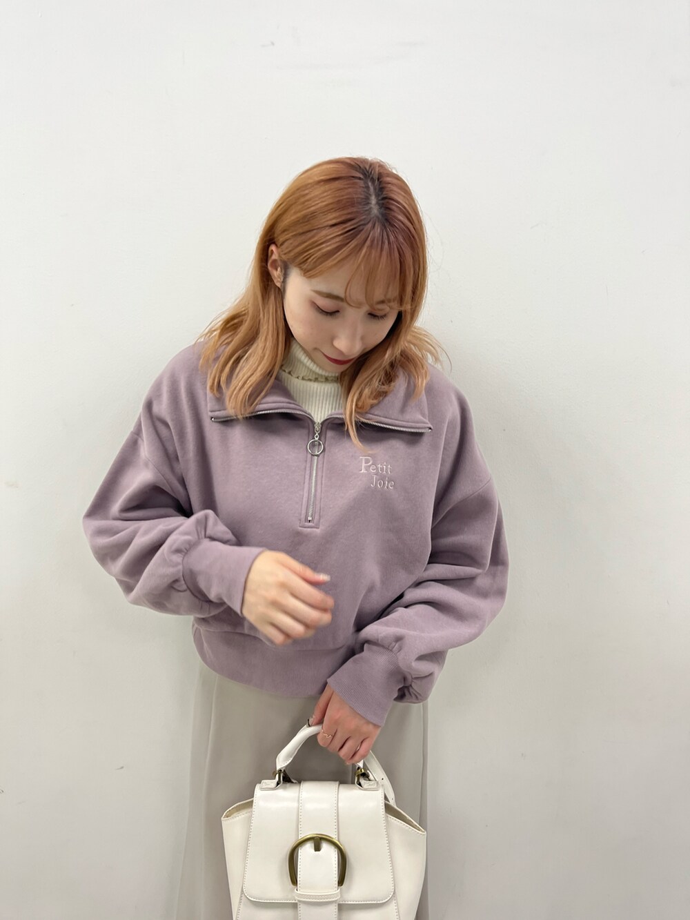 パープル系のスウェット、ベージュ系のスカート、ホワイト系のスニーカーを着用したレディースの冬コーディネートの3枚目の写真