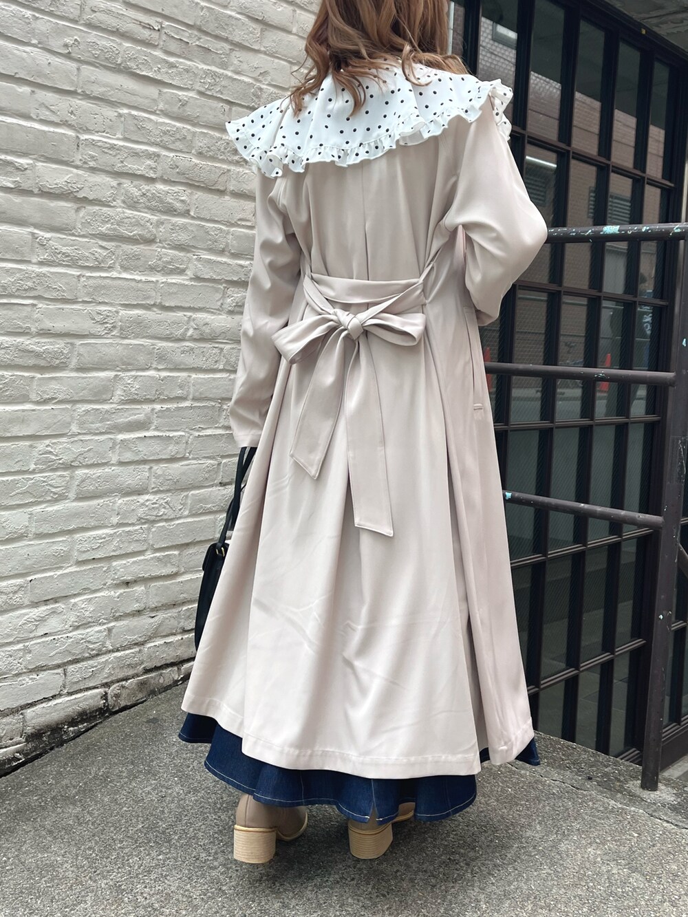 ホワイト系のシャツ/ブラウス、ホワイト系のトレンチコート、ブラック系のショルダーバッグを着用したレディースの春コーディネートの2枚目の写真