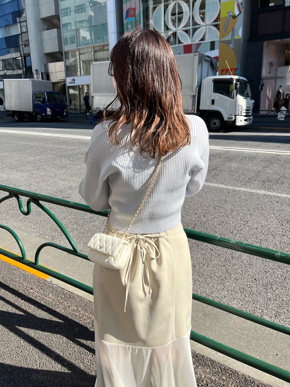 ブルー系のカーディガン/ボレロ、ホワイト系のスカートを着用したレディースの冬コーディネートの3枚目の写真