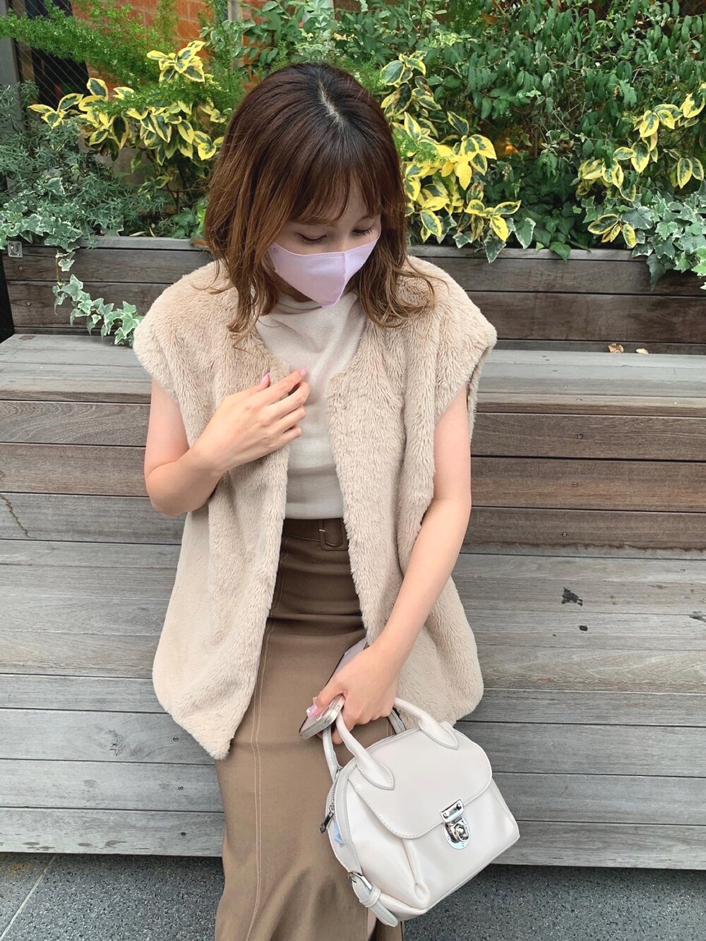 ブラウン系のスカート、ブラウン系のブーツ、ベージュ系のベストを着用したレディースの夏コーディネートの2枚目の写真