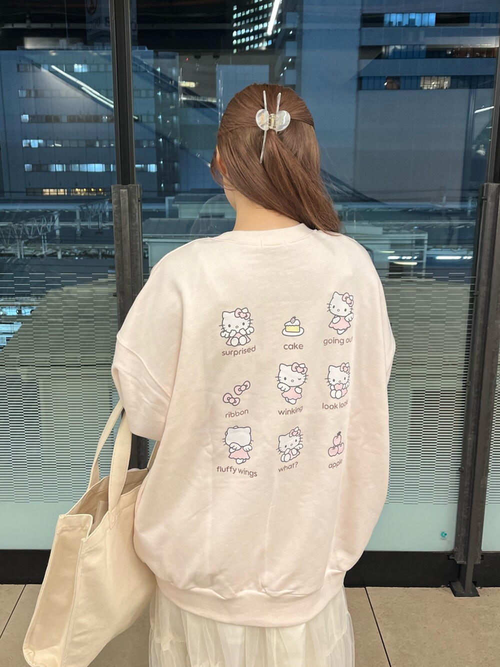 ピンク系のトップス、ホワイト系のワンピースを着用したレディースの冬コーディネートの2枚目の写真