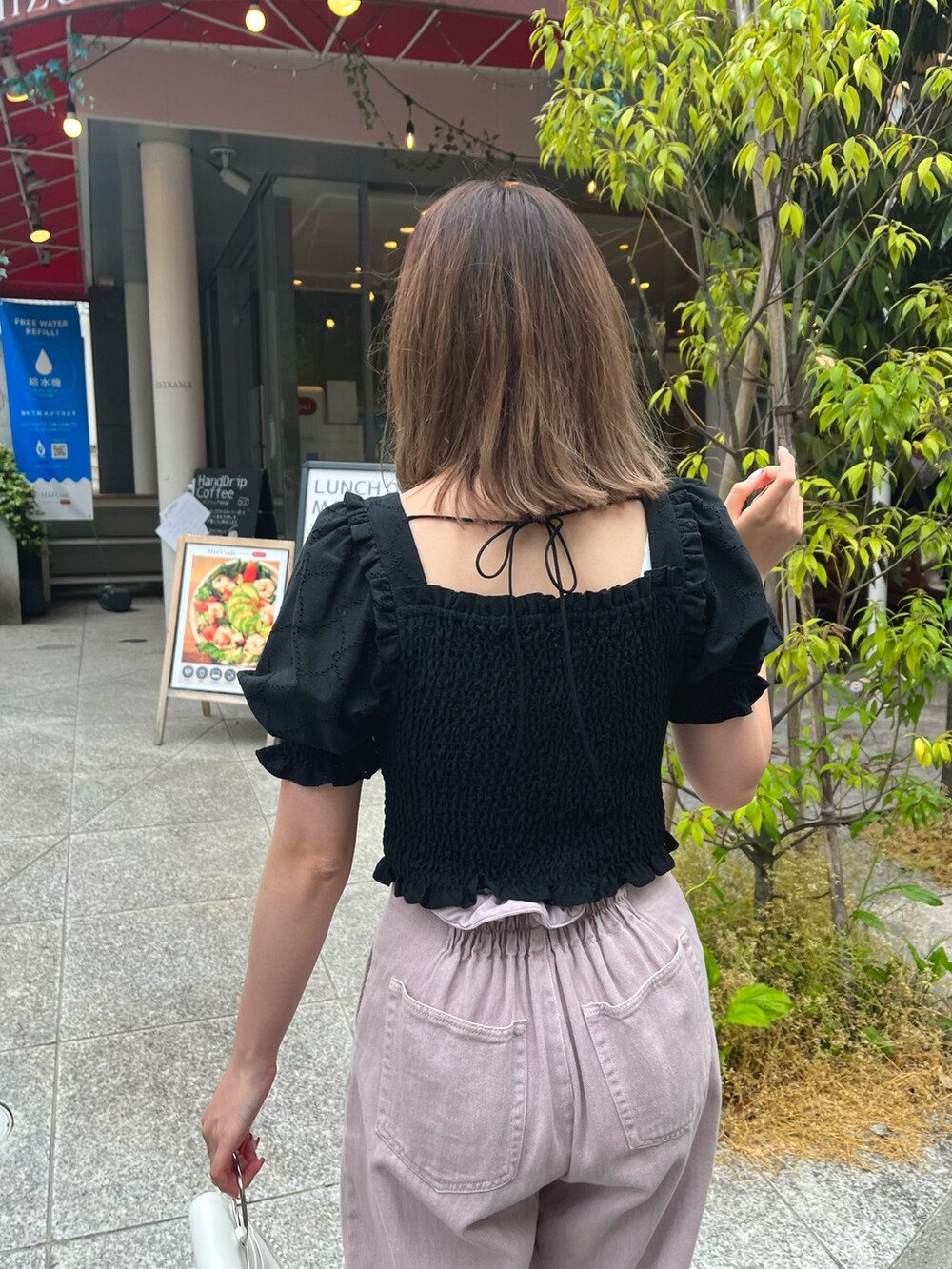 ブラック系のシャツ/ブラウス、パープル系のデニムパンツ、ホワイト系のショルダーバッグを着用したレディースの春コーディネートの3枚目の写真