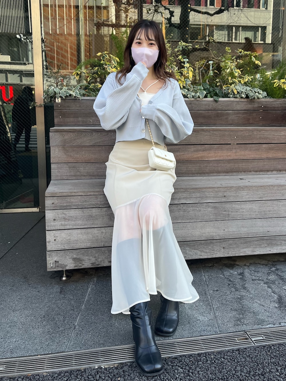 ブルー系のカーディガン/ボレロ、ホワイト系のスカートを着用したレディースの冬コーディネートの2枚目の写真