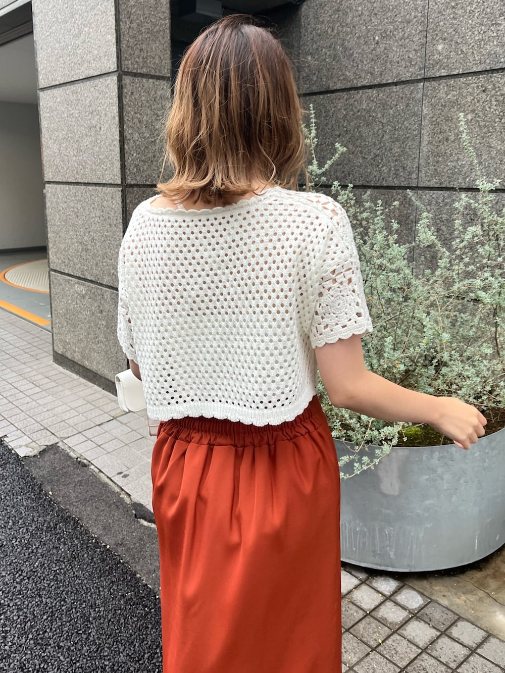 ホワイト系のカーディガン/ボレロ、オレンジ系のスカート、ベージュ系のサンダルを着用したレディースの夏コーディネートの3枚目の写真