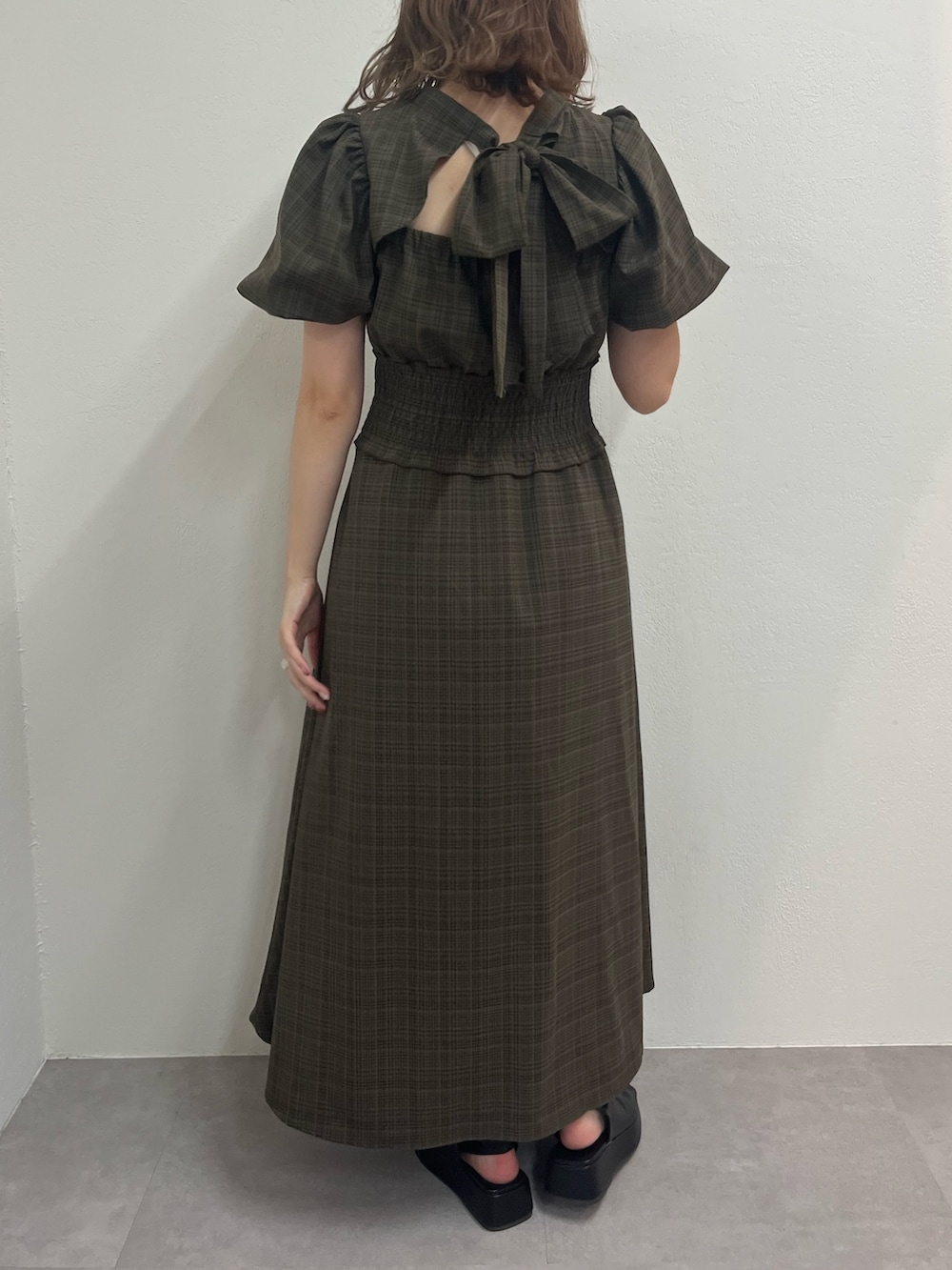 ブラウン系のワンピース、ブラック系のブーツを着用したレディースの夏コーディネートの2枚目の写真