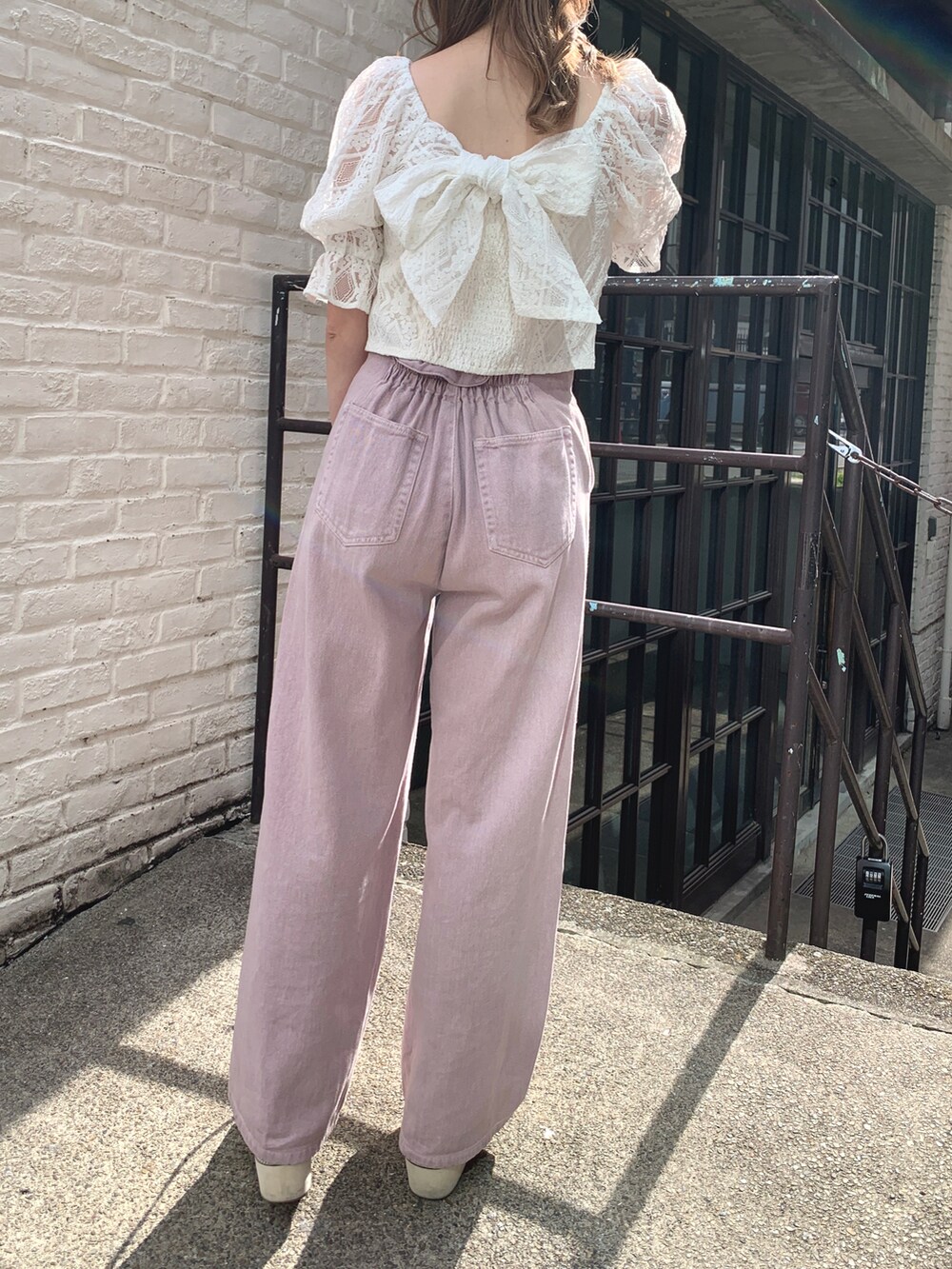 ホワイト系のシャツ/ブラウス、パープル系のデニムパンツ、シルバー系のショルダーバッグを着用したレディースの春コーディネートの2枚目の写真