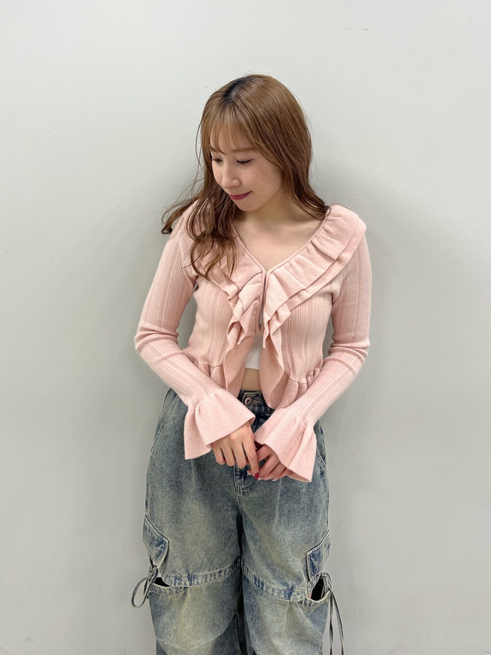 ピンク系のカーディガン/ボレロ、ブルー系のカーゴパンツを着用したレディースの春コーディネートの2枚目の写真