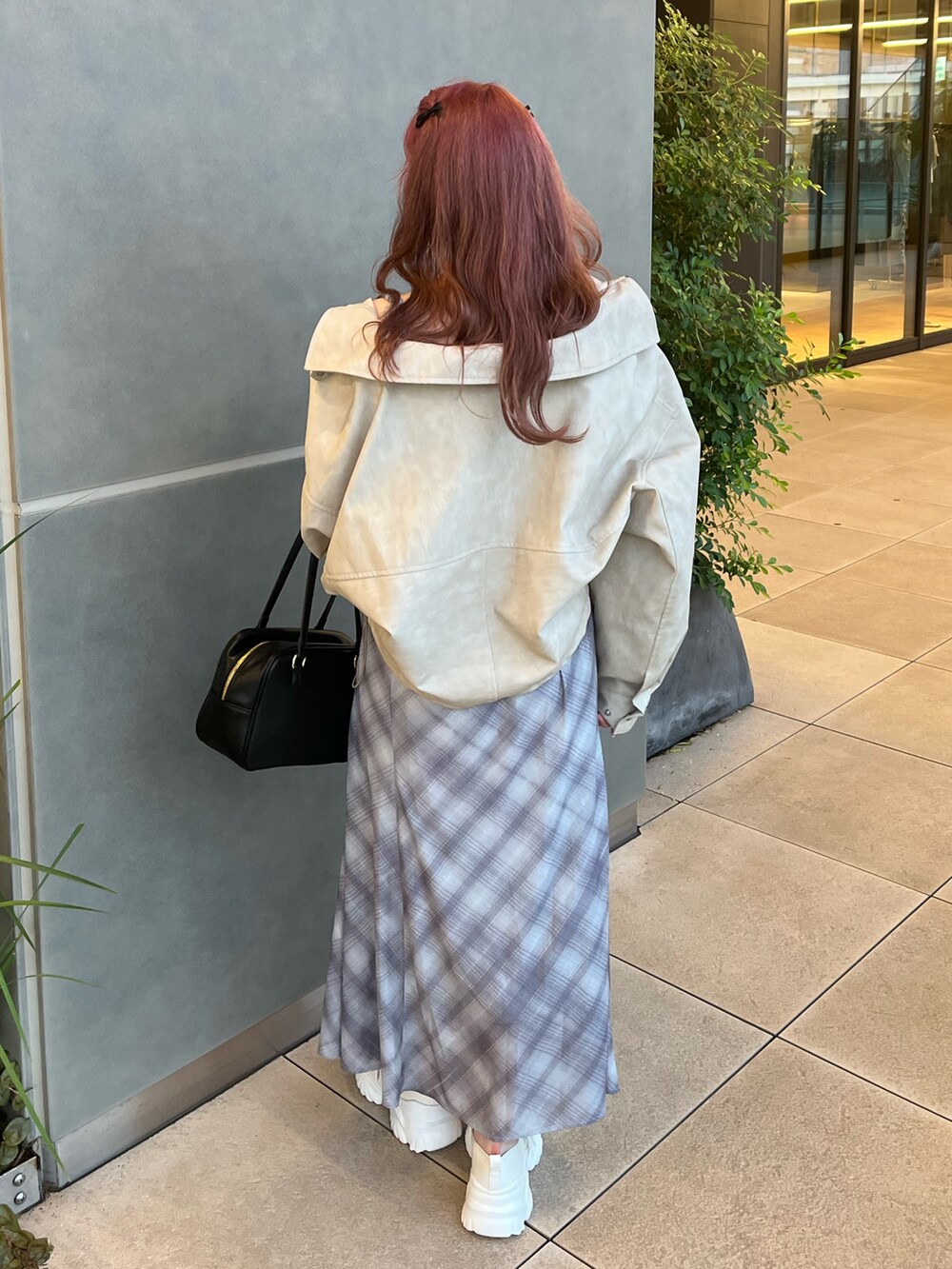 ホワイト系のブルゾン、ブラウン系のワンピース、ホワイト系のスニーカーを着用したレディースの秋コーディネートの3枚目の写真