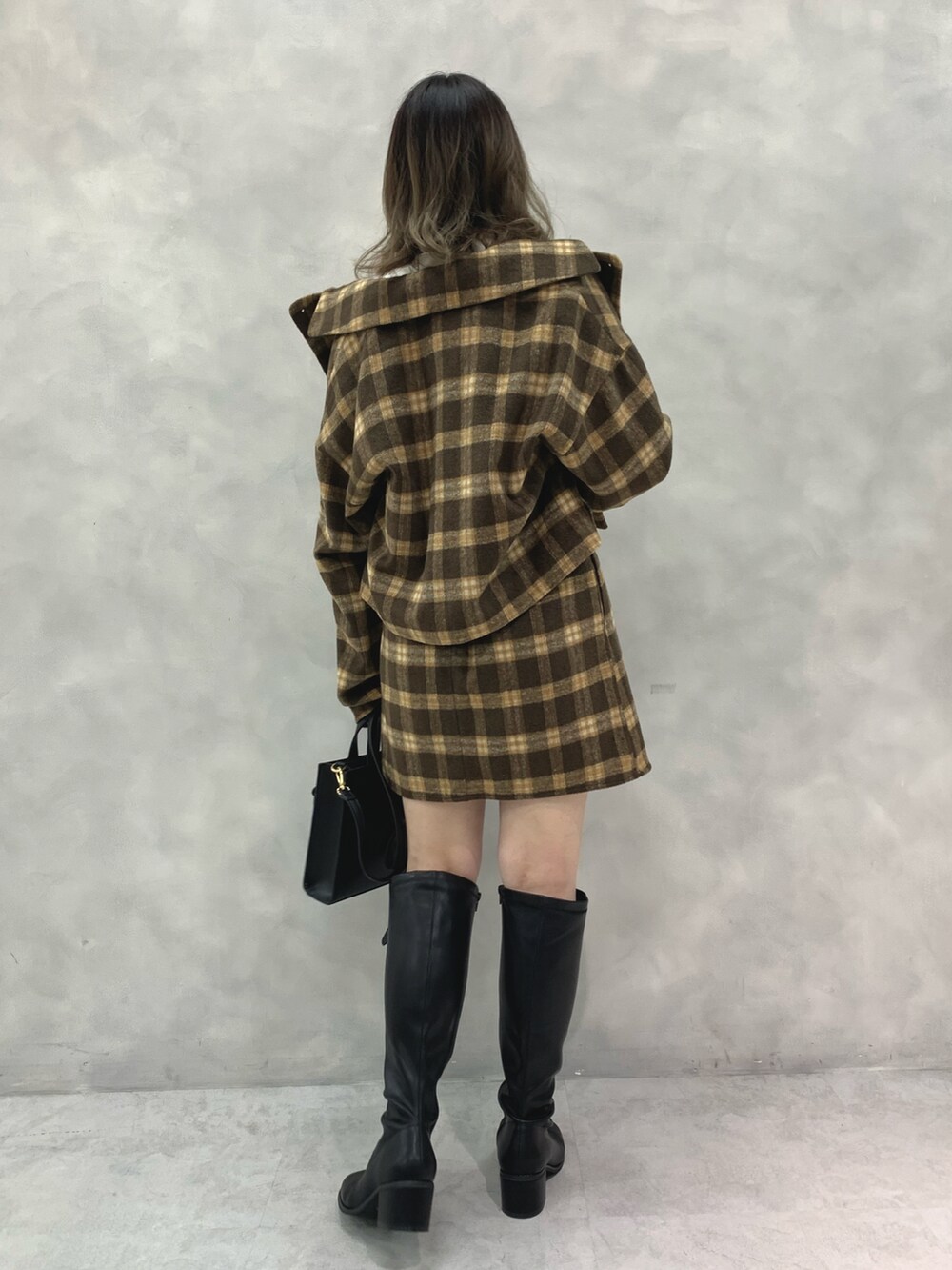 ブラウン系のワンピース、ブラック系のブーツ、ブラック系のショルダーバッグを着用したレディースの秋コーディネートの2枚目の写真