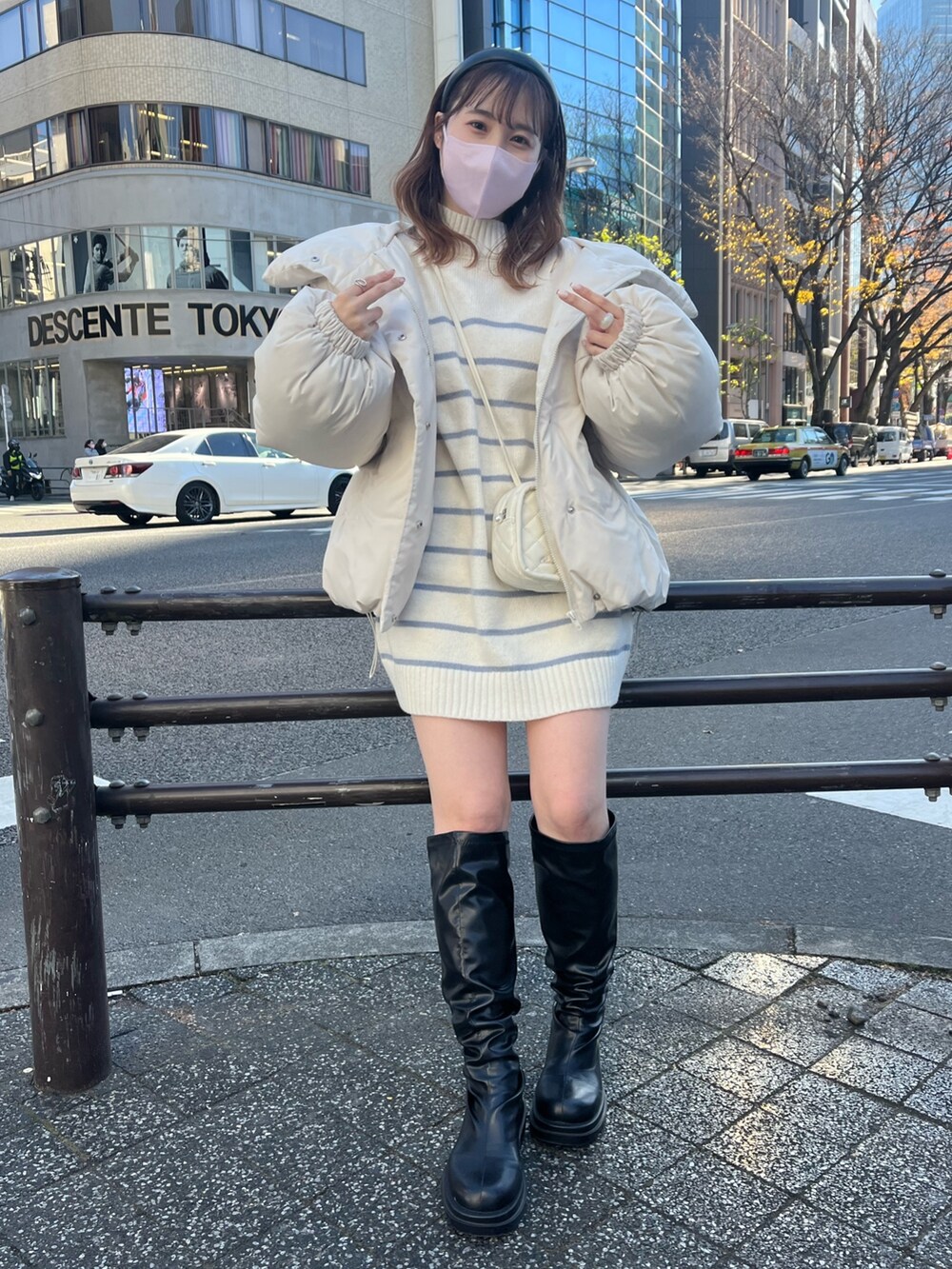 ブラック系のダウンジャケット/コート、ブルー系のニット/セーター、ブラック系のブーツを着用したレディースの冬コーディネートの2枚目の写真