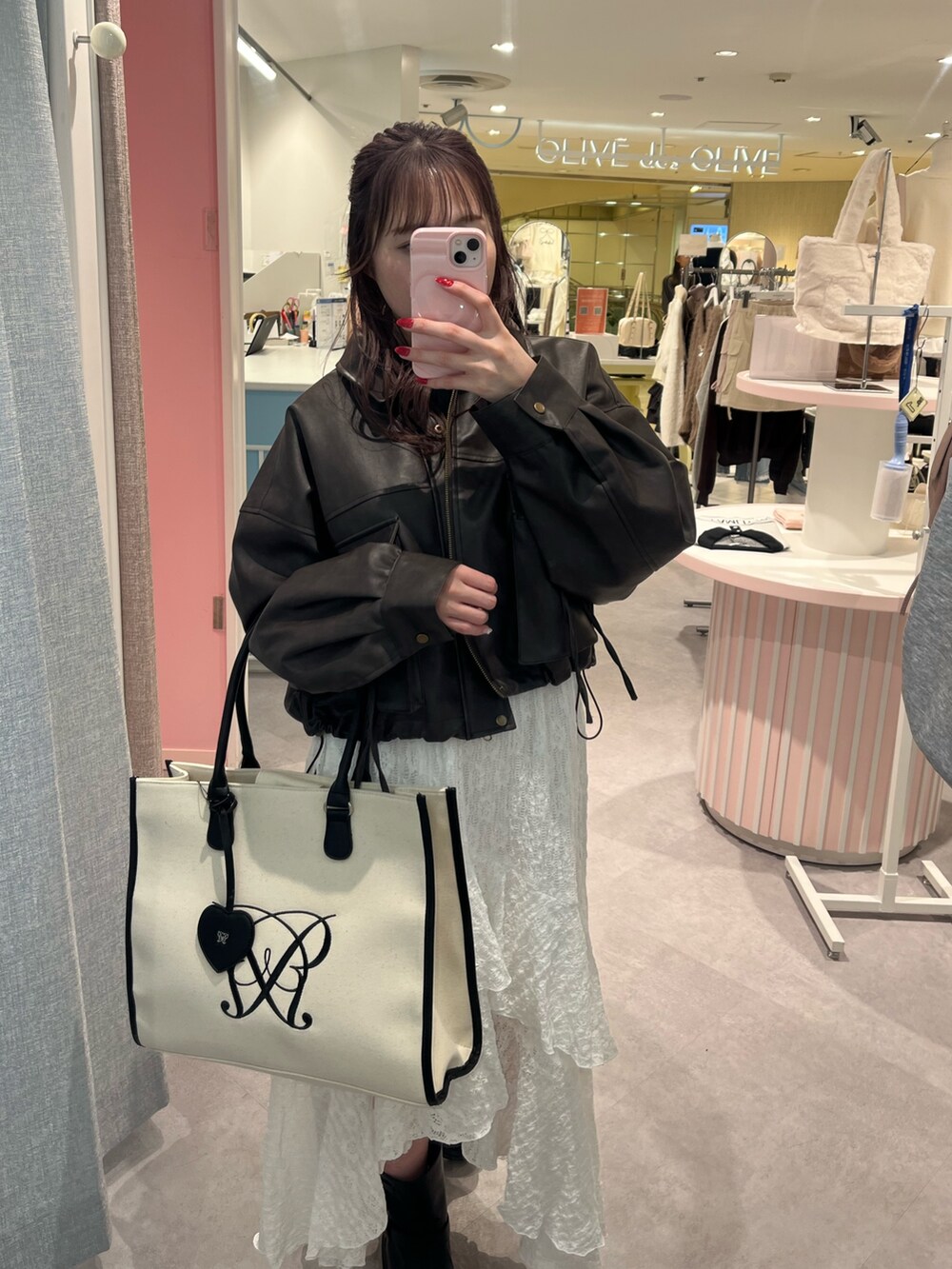 ブラック系のブルゾン、ホワイト系のワンピース、ホワイト系のトートバッグを着用したレディースの冬コーディネートの2枚目の写真